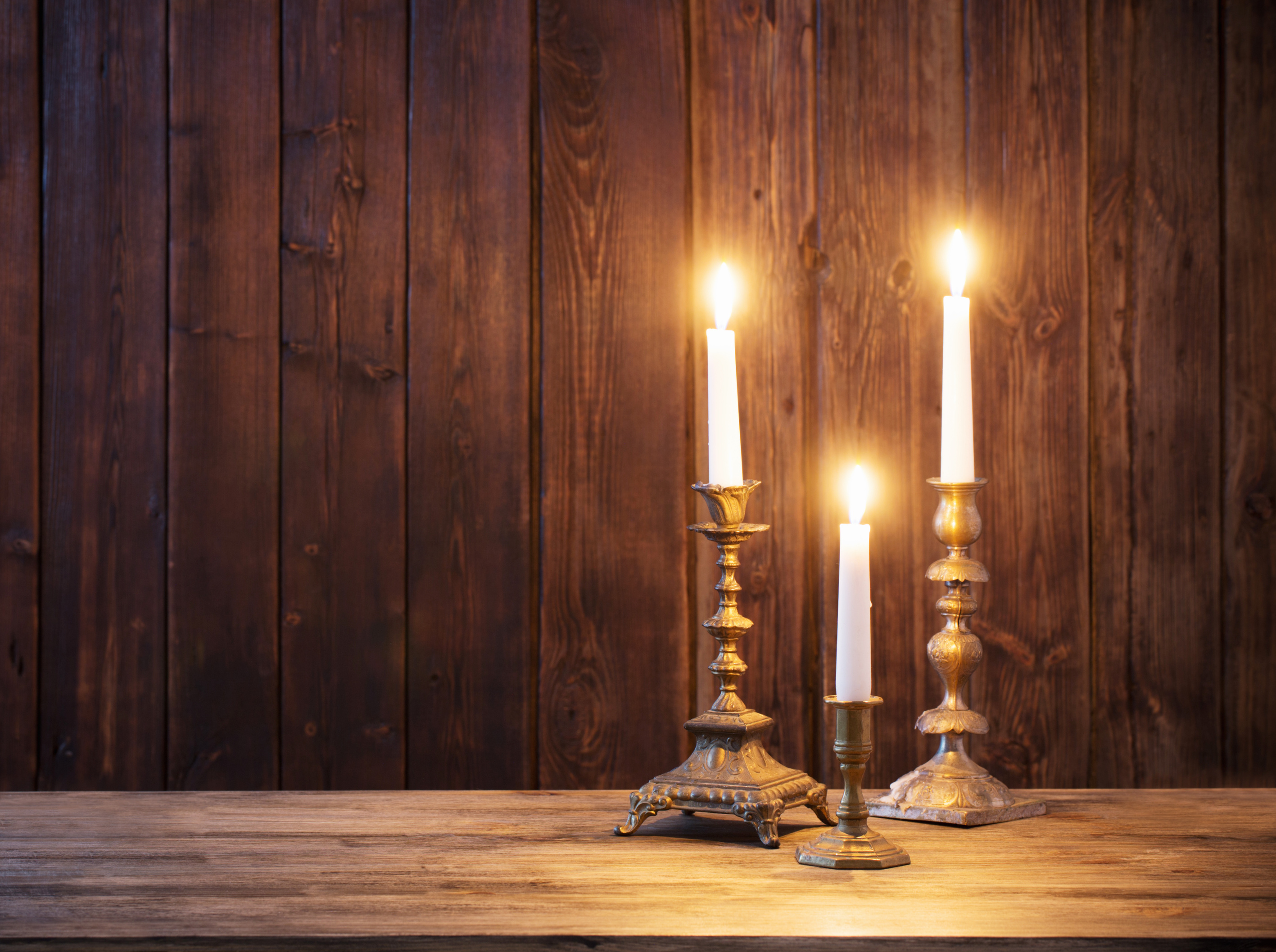 burning candle on old wooden background